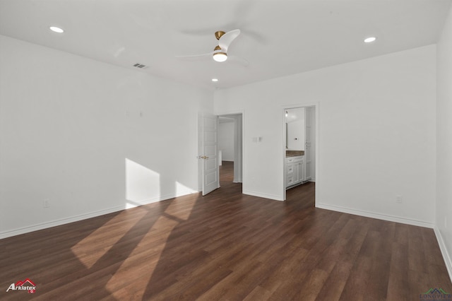 unfurnished bedroom with ceiling fan, ensuite bathroom, and dark wood-type flooring