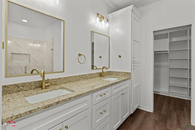 bathroom featuring hardwood / wood-style flooring, vanity, and walk in shower