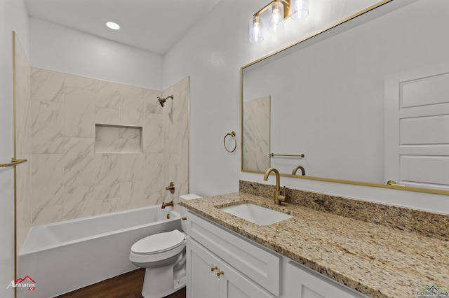 full bathroom featuring hardwood / wood-style flooring, toilet, vanity, and tiled shower / bath