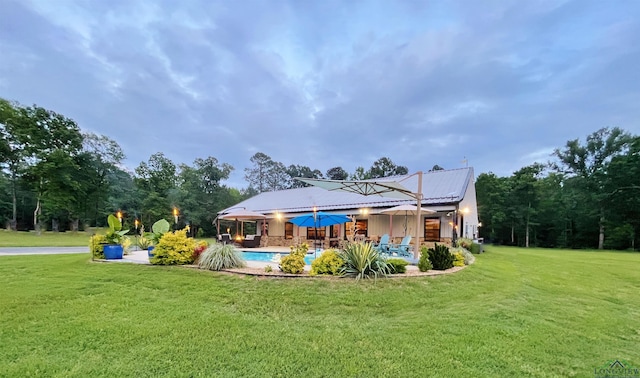 rear view of house featuring a yard and solar panels