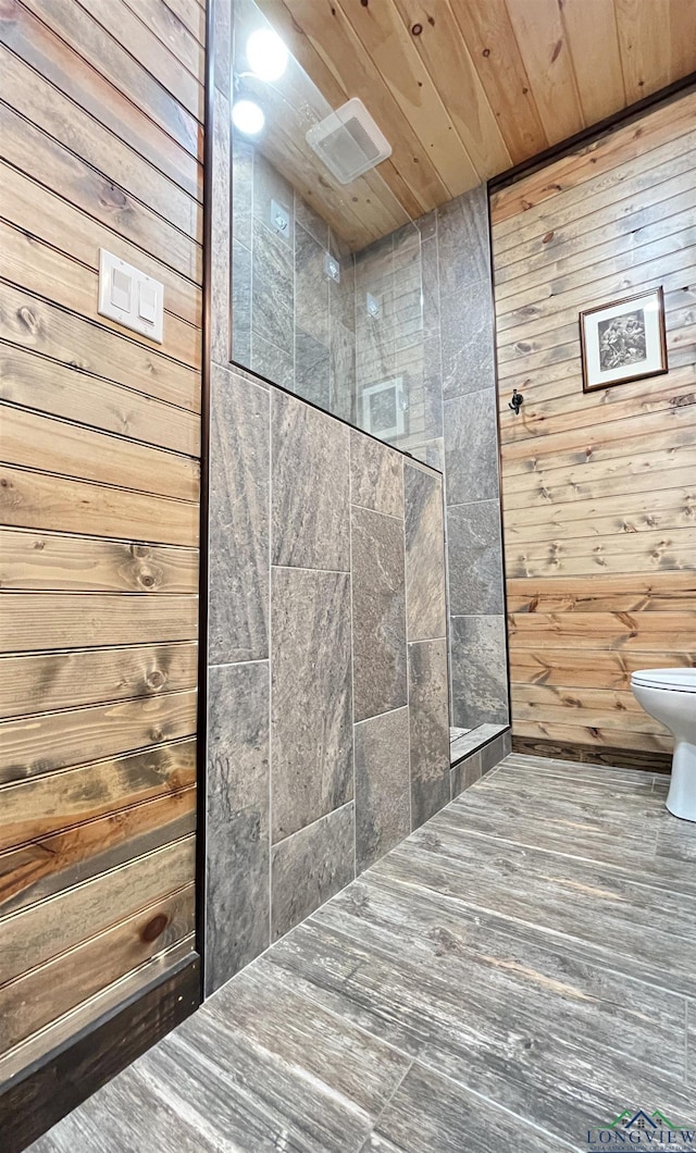 bathroom with wood ceiling, wooden walls, and toilet