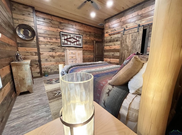 sitting room featuring hardwood / wood-style flooring, wooden walls, wooden ceiling, and a barn door