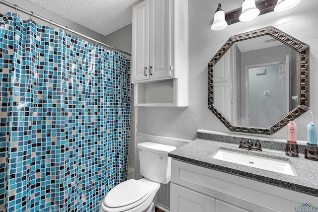 bathroom with a textured ceiling, toilet, and vanity