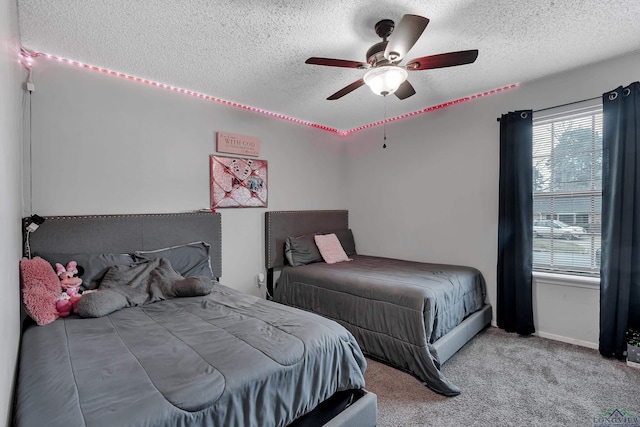 bedroom featuring carpet, multiple windows, a textured ceiling, and ceiling fan