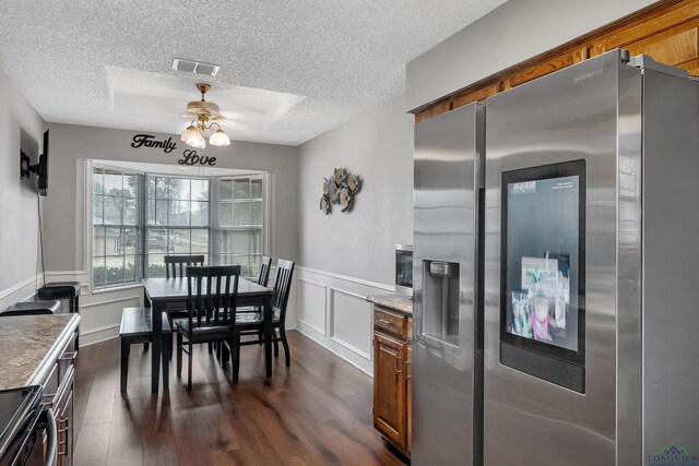 kitchen featuring ceiling fan, a textured ceiling, appliances with stainless steel finishes, and dark hardwood / wood-style flooring