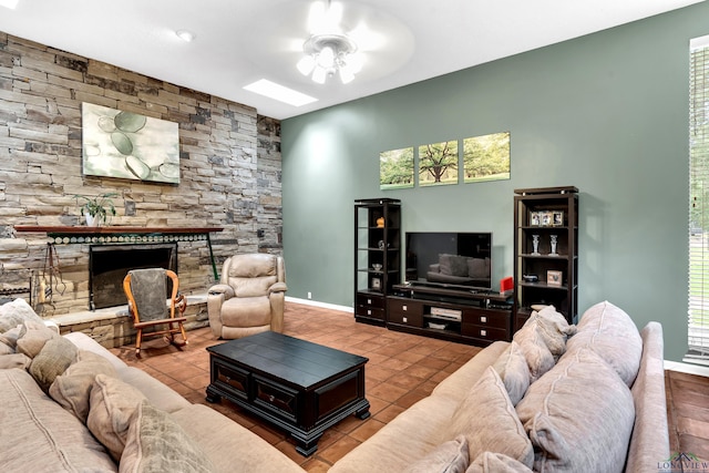 414 Harper Dr, Marshall, TX 75672 - tiled living room with baseboards, a ceiling fan, and a stone fireplace