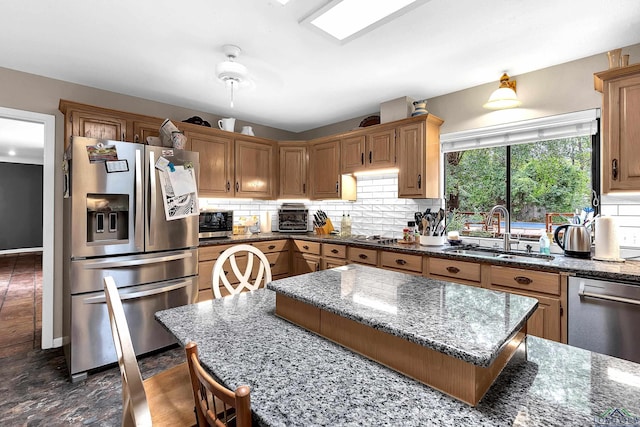414 Harper Dr, Marshall, TX 75672 - kitchen featuring decorative backsplash, dark stone countertops, stainless steel appliances, and a sink