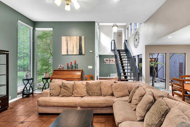 414 Harper Dr, Marshall, TX 75672 - tiled living room featuring a textured ceiling, baseboards, visible vents, a ceiling fan, and stairway
