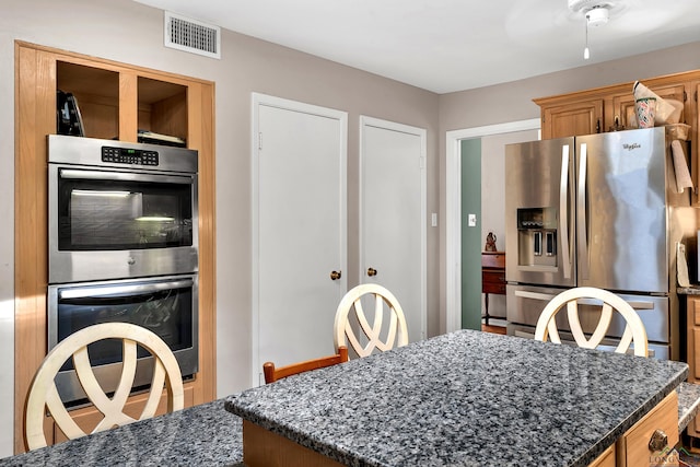 414 Harper Dr, Marshall, TX 75672 - kitchen featuring visible vents, a kitchen island, dark stone countertops, and appliances with stainless steel finishes