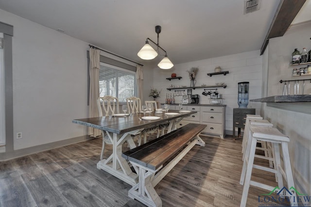 dining room featuring wood finished floors, visible vents, and baseboards