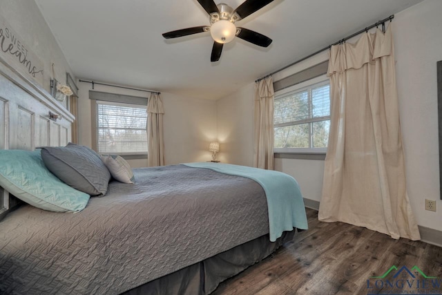 bedroom with multiple windows, wood finished floors, and a ceiling fan