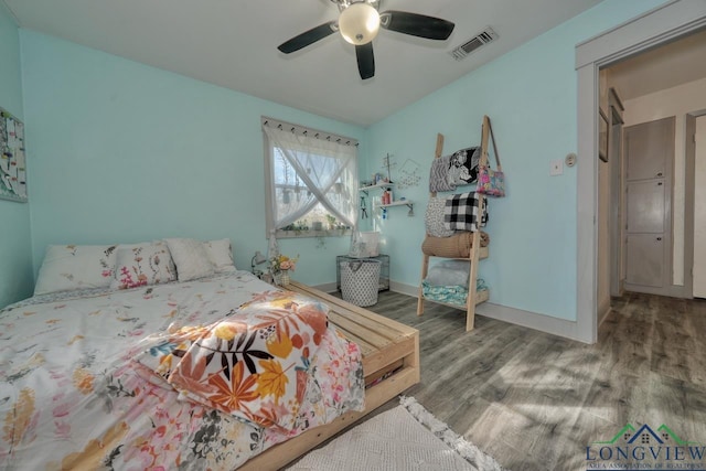 bedroom featuring ceiling fan, wood finished floors, visible vents, and baseboards