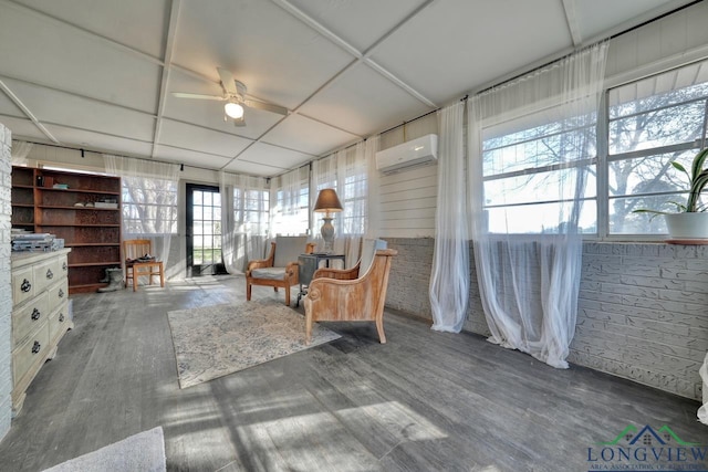 living area featuring an AC wall unit, a ceiling fan, and wood finished floors