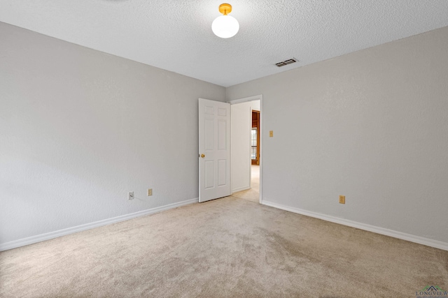 1307 Spring Tree Ln, Kilgore, TX 75662 - empty room featuring light colored carpet, a textured ceiling, and baseboards