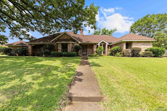 1307 Spring Tree Ln, Kilgore, TX 75662 - ranch-style house featuring a chimney, a front lawn, and brick siding