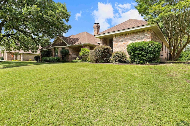 1307 Spring Tree Ln, Kilgore, TX 75662 - view of front of home featuring brick siding, a chimney, a front yard, and a shingled roof