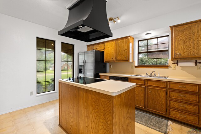 1307 Spring Tree Ln, Kilgore, TX 75662 - kitchen featuring stainless steel fridge, a sink, custom range hood, black electric stovetop, and brown cabinets