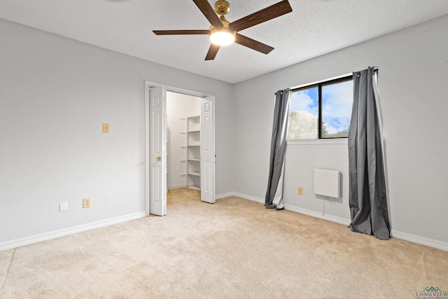 1307 Spring Tree Ln, Kilgore, TX 75662 - unfurnished bedroom with light colored carpet, ceiling fan, a textured ceiling, baseboards, and a spacious closet