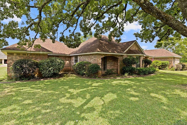 1307 Spring Tree Ln, Kilgore, TX 75662 - view of front of home with brick siding, a front yard, and roof with shingles