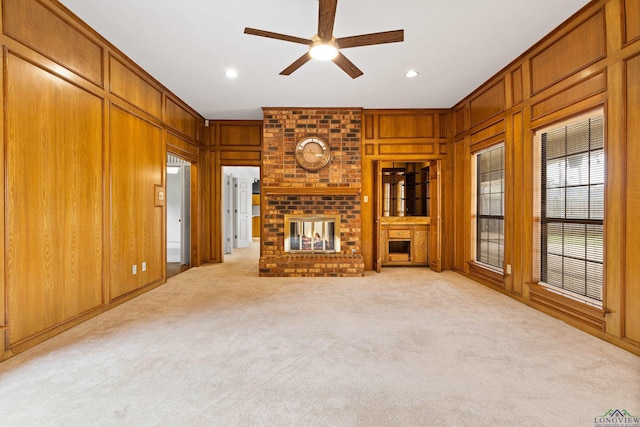 1307 Spring Tree Ln, Kilgore, TX 75662 - unfurnished living room with ceiling fan, a brick fireplace, carpet, wood walls, and recessed lighting