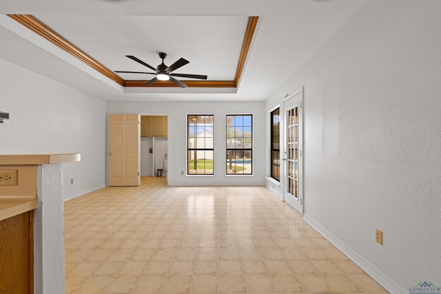 1307 Spring Tree Ln, Kilgore, TX 75662 - unfurnished living room featuring a tray ceiling, a ceiling fan, baseboards, and light floors
