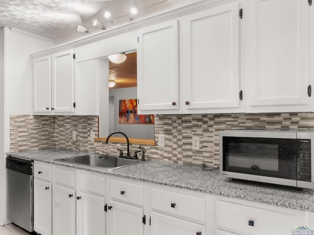 3506 Dudley Rd, Kilgore, TX 75662 - kitchen with appliances with stainless steel finishes, a sink, white cabinets, and backsplash