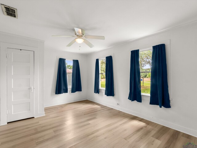 3506 Dudley Rd, Kilgore, TX 75662 - empty room with plenty of natural light, light wood finished floors, a ceiling fan, baseboards, and ornamental molding
