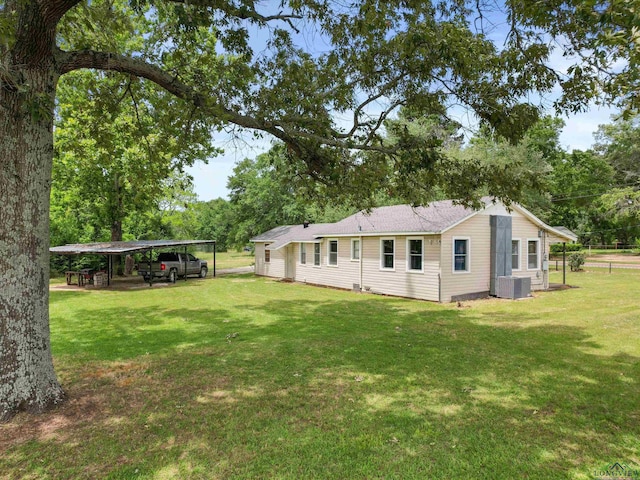3506 Dudley Rd, Kilgore, TX 75662 - back of house featuring a detached carport, central AC unit, and a lawn