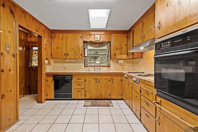 kitchen with black appliances, backsplash, light tile patterned floors, and sink