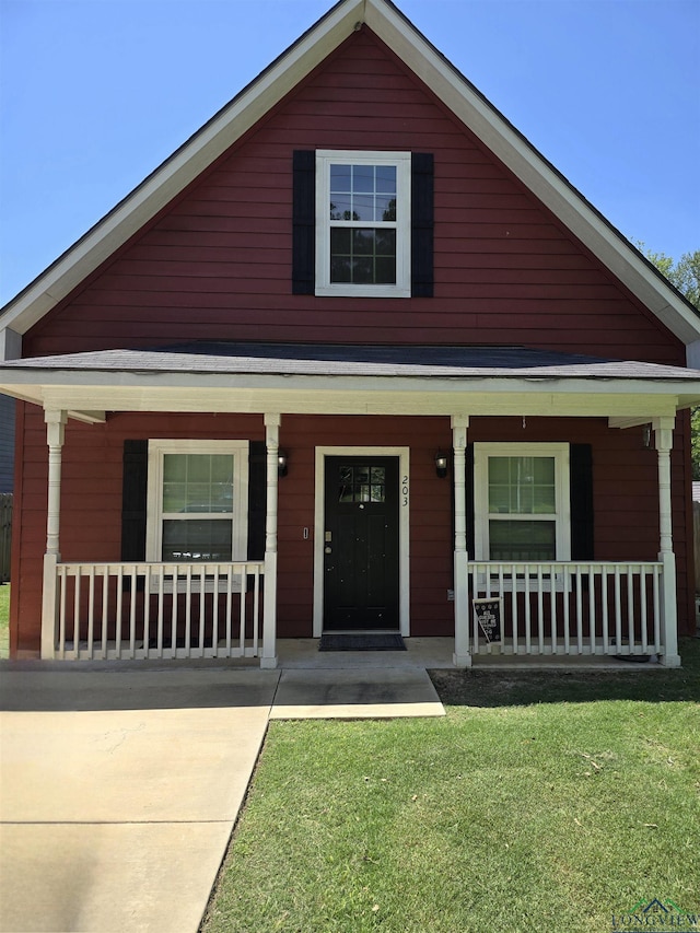 203 W Gay Ave, Gladewater, TX 75647 - view of front facade with covered porch and a front lawn