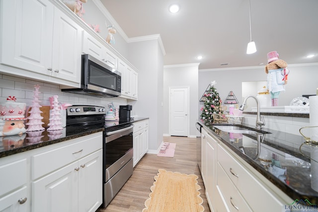 kitchen featuring dark stone countertops, white cabinetry, sink, and appliances with stainless steel finishes