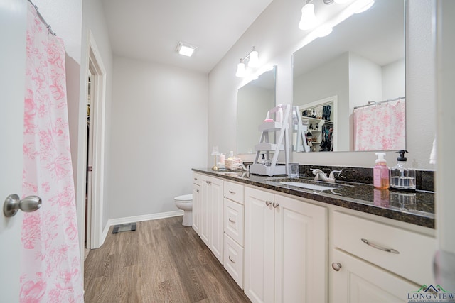 bathroom with hardwood / wood-style floors, vanity, and toilet