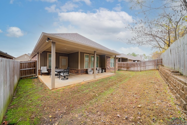 back of property featuring a lawn and a patio area