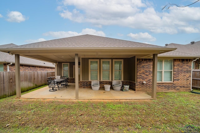 back of property featuring a patio area and a yard