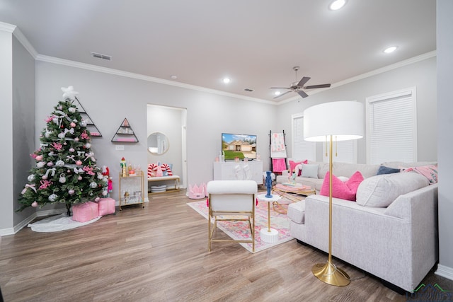 living room with hardwood / wood-style floors, ceiling fan, and ornamental molding