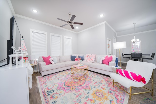 living room with dark wood-type flooring, ceiling fan with notable chandelier, and ornamental molding