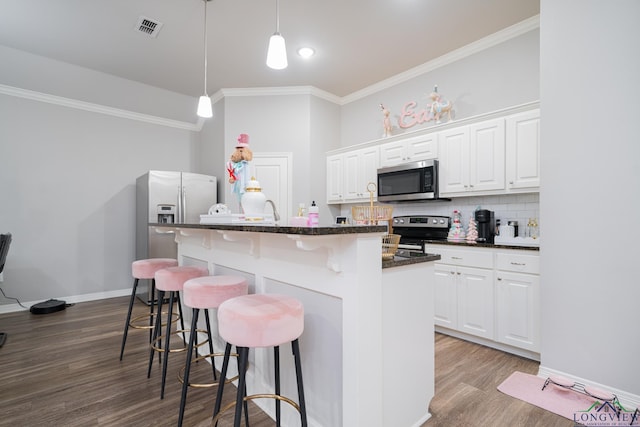 kitchen featuring white cabinets, stainless steel appliances, tasteful backsplash, and a center island with sink