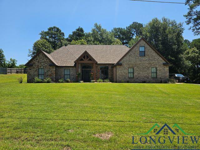 240 Cedar Ridge Rd, Longview, TX 75602 - tudor home featuring a front yard and stone siding