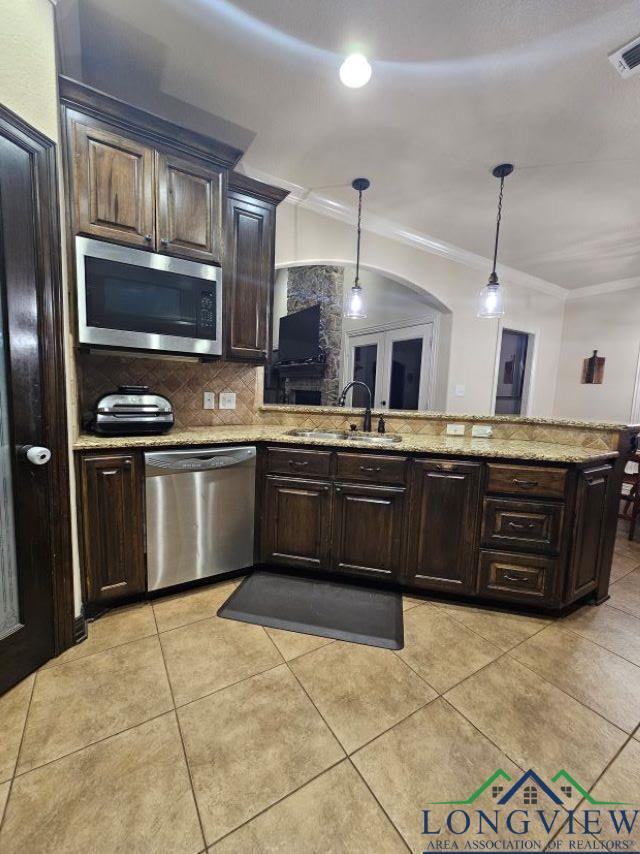 240 Cedar Ridge Rd, Longview, TX 75602 - kitchen with stainless steel appliances, a sink, ornamental molding, arched walkways, and decorative light fixtures