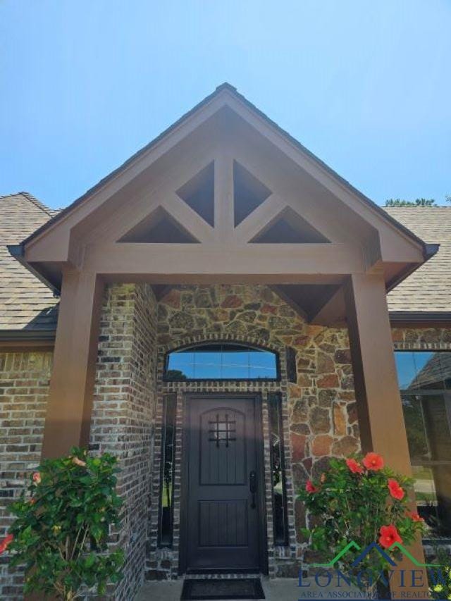 240 Cedar Ridge Rd, Longview, TX 75602 - property entrance featuring brick siding, roof with shingles, and stone siding