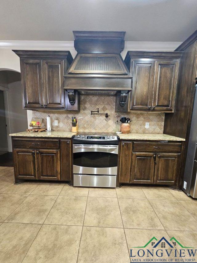 240 Cedar Ridge Rd, Longview, TX 75602 - kitchen with stainless steel range with electric cooktop, premium range hood, dark brown cabinetry, tasteful backsplash, and crown molding