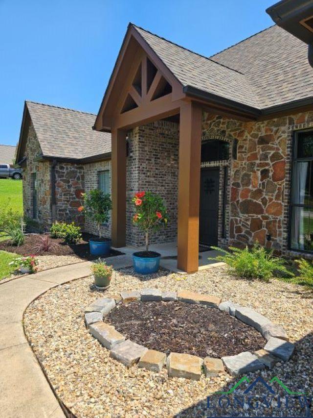 240 Cedar Ridge Rd, Longview, TX 75602 - view of property exterior featuring a shingled roof and stone siding