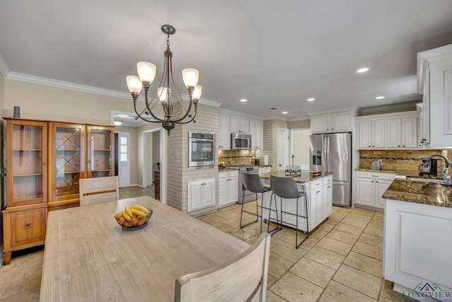 dining space featuring ornamental molding, sink, and a chandelier