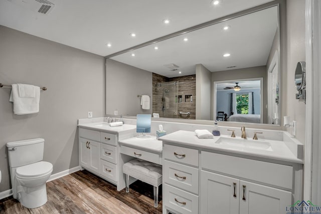 bathroom with walk in shower, vanity, ceiling fan, wood-type flooring, and toilet