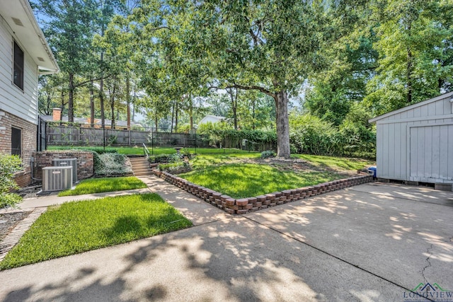 view of yard featuring central AC, a patio, and a storage shed