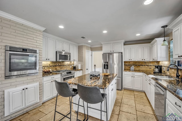 kitchen featuring backsplash, sink, a kitchen island, and stainless steel appliances