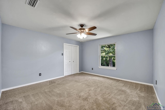 carpeted spare room with ceiling fan