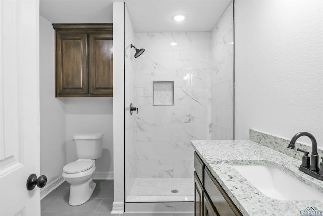 bathroom featuring tiled shower, vanity, toilet, and tile patterned flooring