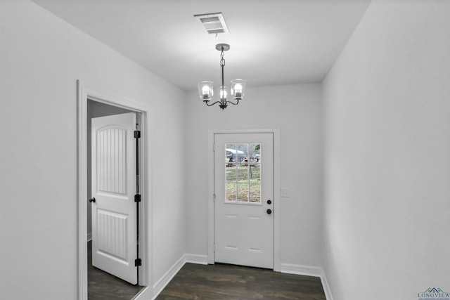 entryway with dark hardwood / wood-style flooring and an inviting chandelier