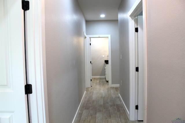 corridor with hardwood / wood-style floors